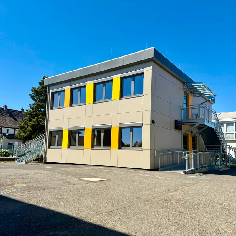 Eichbaumschule Büdingen: Längsseite mit Fensterbändern und gelben Fassadenfeldern